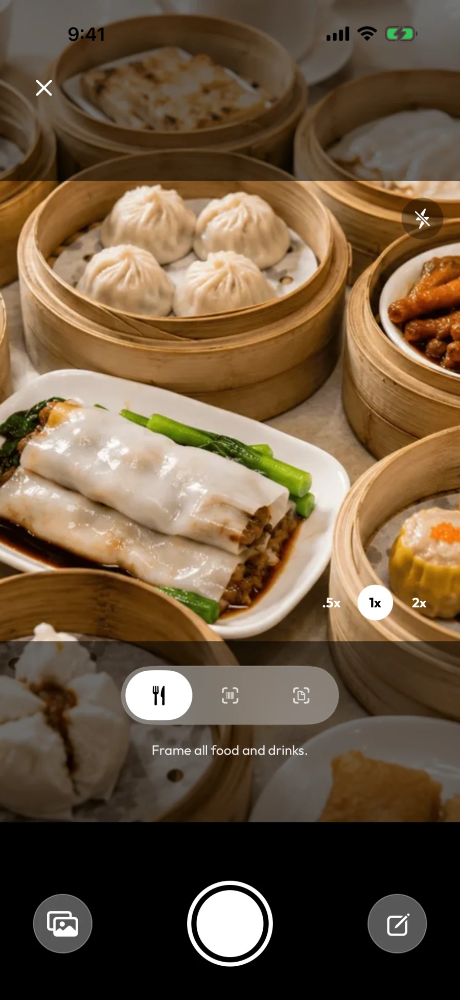 The Food scanner capture screen: a dim sum spread in the viewfinder, with the "Frame all food and drinks." prompt, zoom controls (0.5x / 1x / 2x), and the shutter button at the bottom